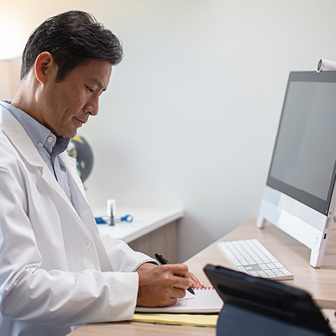Male doctor looking at his notes
