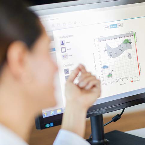 Professional using hearing aid fitting software.