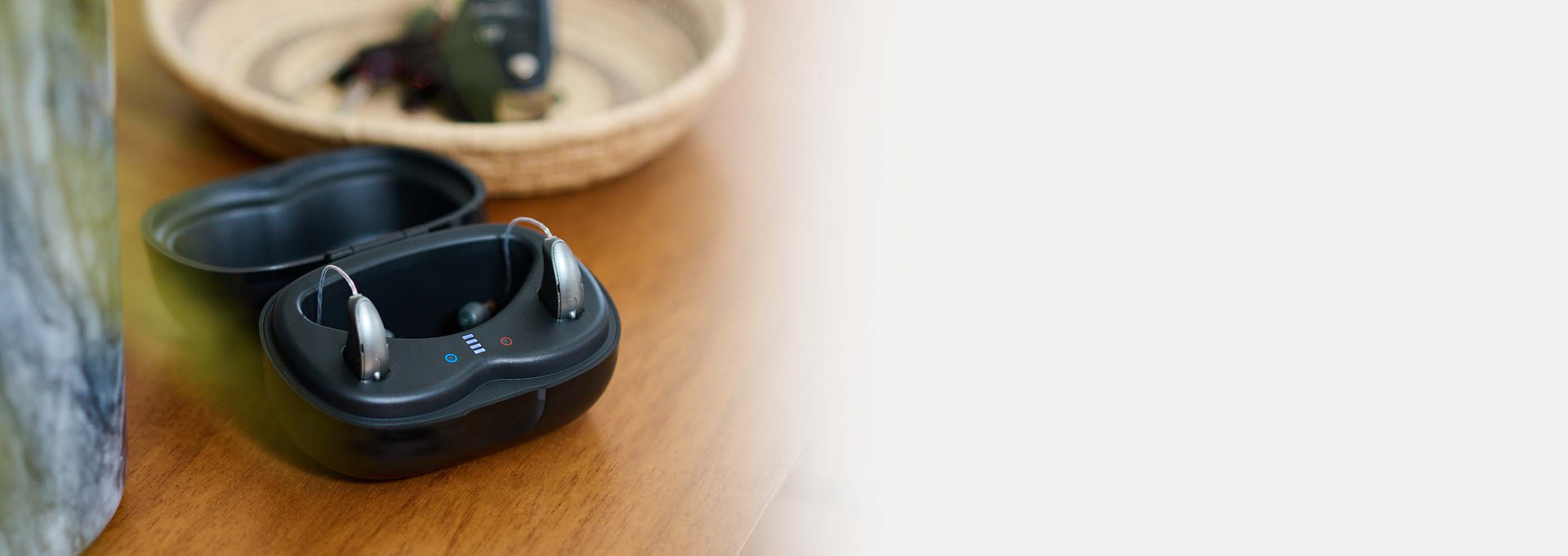 Hearing aids in a charger sitting on a nightstand.