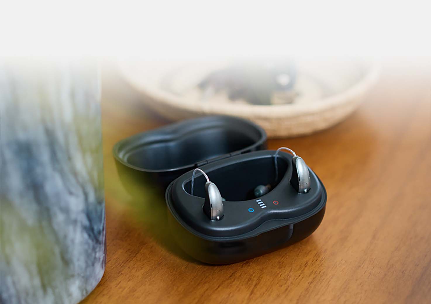 Hearing aids in a charger sitting on a nightstand.