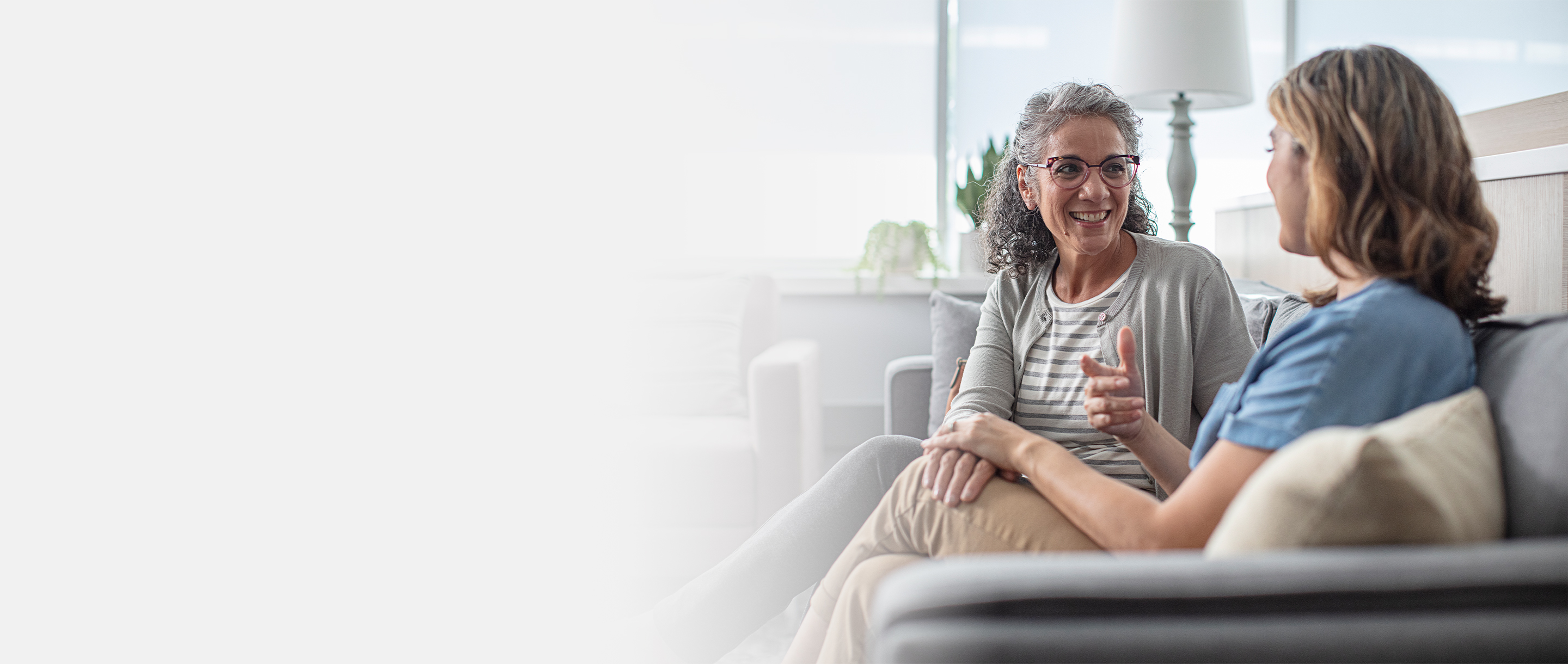 Two females talking on a couch